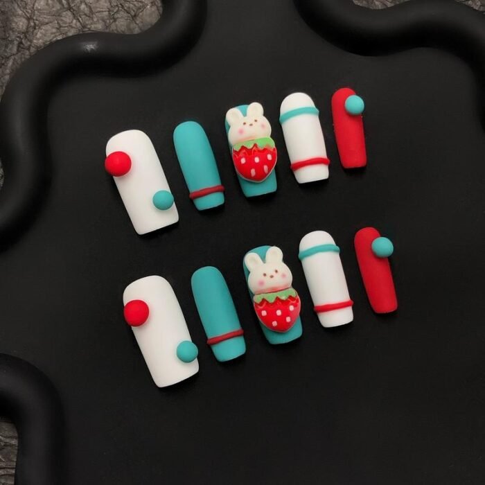 Macro close-up of 3D bunny strawberry nail art with color dot accents on short square nails